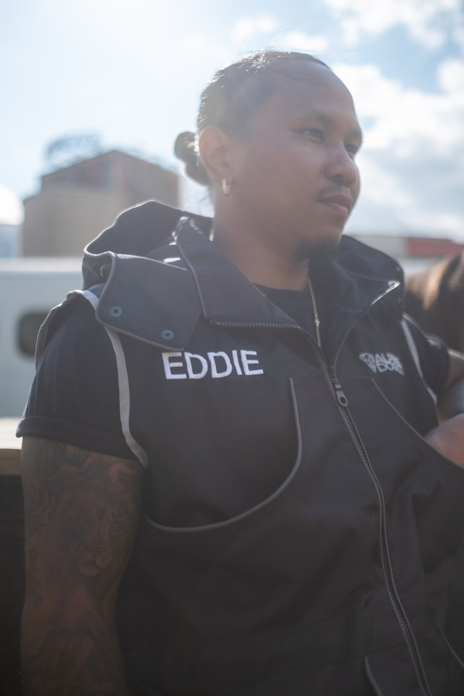 Dog trainer wearing a black Alpine Dog training vest with reflective piping and embroidered chest pockets outdoors